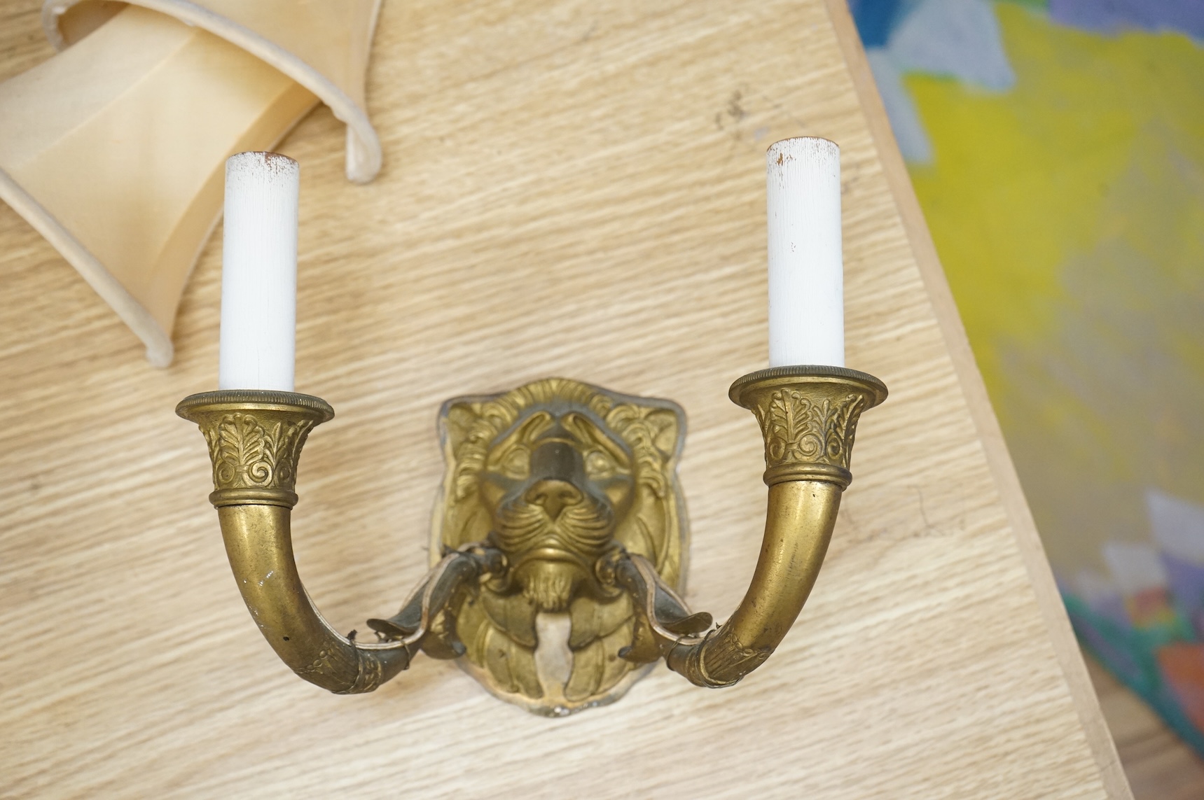 A pair of ‘lion mask’ gilt metal two branch wall sconces and four silk shades, 22cm wide